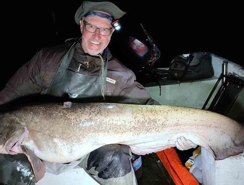 Das Bild zeigt Klaus mit einem Wels, den er soeben gefangen hat und der eine Länge von 173 cm hat.